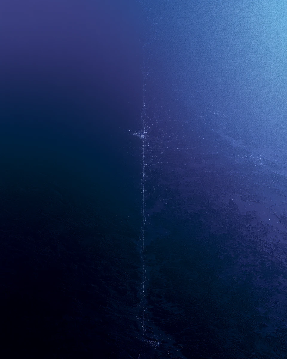 A single infrastructure corridor picked out in cool light running across dark terrain.