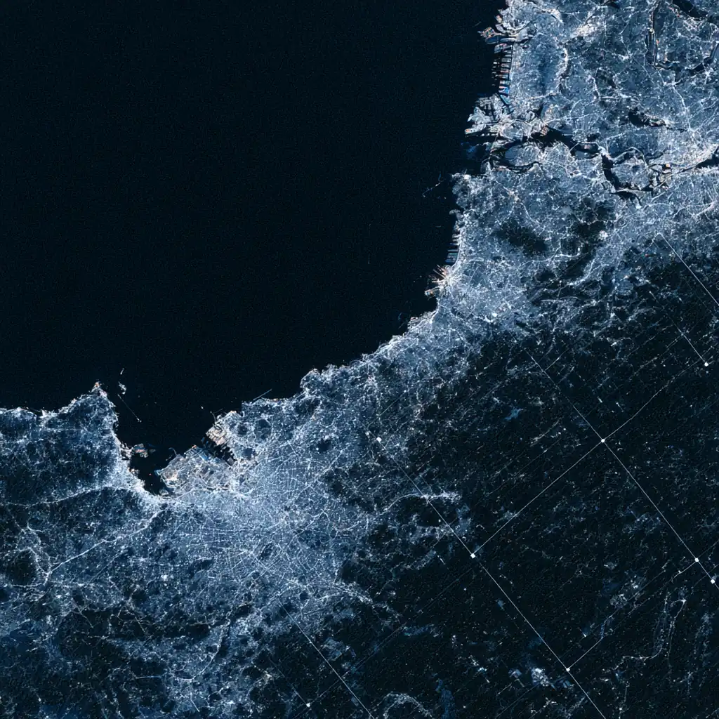 A night satellite view of coastal infrastructure in cool blue, overlaid with a faint hairline grid.